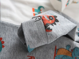 Close-up of elastic ribbed cuff on boys' long sleeve tee with cartoon dinosaur print