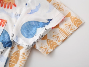 Detailed view of kids cotton short-sleeve shirt with blue whale and sun prints