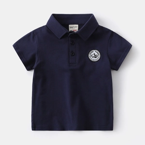 Detail of navy blue boys polo shirt collar with buttons and embroidered chest patch