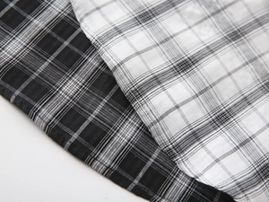 Close-up of the woven texture and neat stitching of the black and white plaid fabric