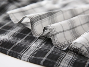 Close-up of black and white plaid fabric texture for kids casual short sleeve shirt