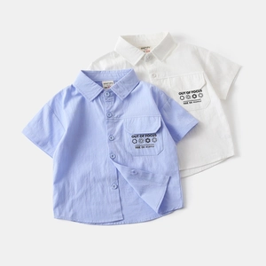 Detail of boys' short-sleeved shirts with pockets and 'OUT OF FOCUS' text design