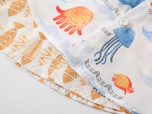 Macro detail of toddler boys shirt featuring colorful cartoon marine animal prints and buttons