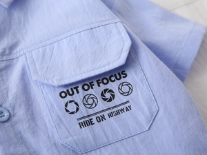 Detail of light blue boys' shirt showing crinkle fabric and printed chest pocket