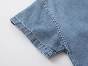 Macro detail of short sleeve cuff with reinforced double stitching on denim shirt