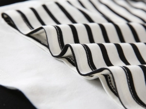 Close-up of black and white striped knit fabric with durable double-needle stitching detail