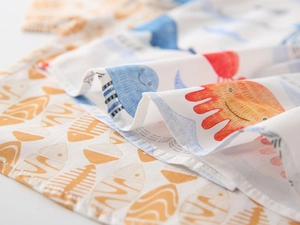 Close-up of soft cotton fabric with cartoon fish and jellyfish prints for boy shirts