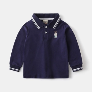 Close-up of navy blue kids polo shirt with white stripes and bear embroidery detail