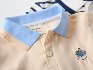 Close-up of baby boy polo shirt featuring blue animal embroidery and contrast collar