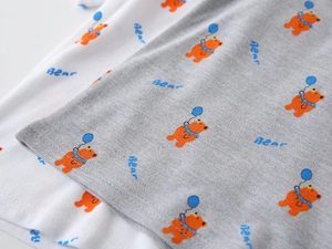 Dettaglio del tessuto in cotone piqué con simpatica stampa di orsetti su polo per bambini