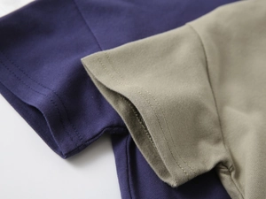Détail des poignets en coton piqué violet et kaki avec des coutures à double aiguille