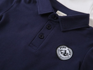 Close-up of navy blue cotton polo shirt with embroidered mountain crest and button collar