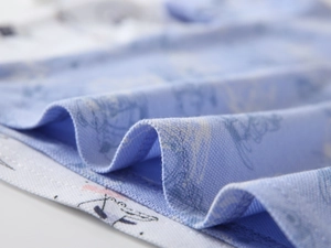 Detailed macro view of the light blue patterned cotton fabric hem and precise stitching work