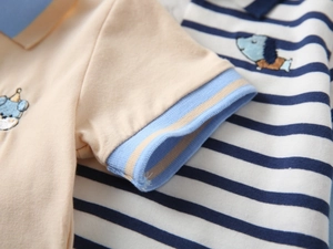 Close-up of boys' cotton polo shirt showing striped fabric and cute puppy embroidery details
