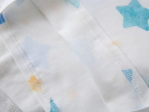 Macro view of boy's white polo shirt showing double-needle stitching and star patterns