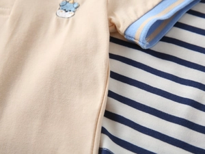 Detailed view of baby boy's cotton polo shirt with cute animal embroidery and striped cuff