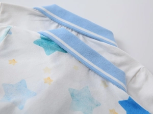 Detail of blue and yellow star pattern on white polo shirt with striped collar