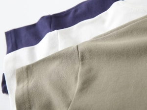 Gros plan de polos pour garçons en coton piqué en bleu marine, blanc et vert kaki