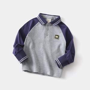 Dettaglio polo a maniche lunghe grigio e blu navy con toppa M e strisce a contrasto