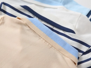 Detail of ribbed collars and stitching on multi-color knitted cotton polo shirts for boys