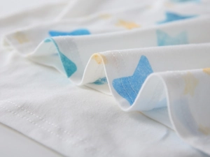 Macro detail of fine stitching on the white cotton polo shirt with star pattern