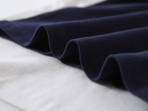 Detailed close-up of navy blue and white knit fabric showing premium stitching quality