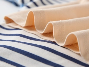 Macro view of cotton fabric showing contrast stripes and high-quality double stitching