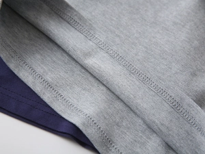 Macro view of overlock stitching detail on gray and navy boys cotton polo shirt