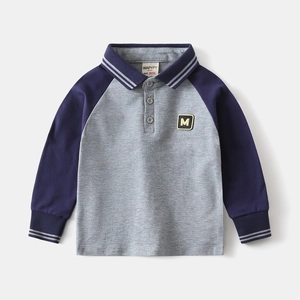 Dettaglio polo per bambini con applicazione M e maniche raglan a contrasto