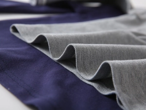 Macro detail of the fine stitching and textured knit fabric on boys' polo shirts