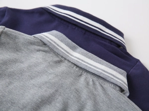 Detail of grey and navy long-sleeved polo collars with white stripes in piqué knit cotton