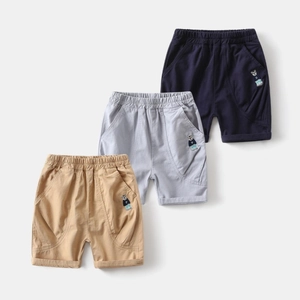 Detail of kids cotton shorts featuring elastic waistband and teddy bear embroidery