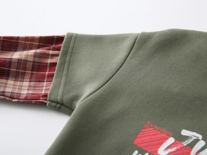 Detail of army green boys sweatshirt featuring layered plaid sleeves and letter print