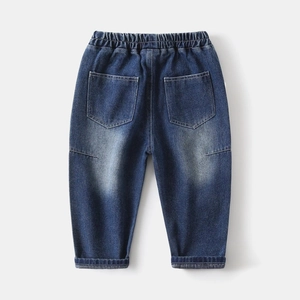 Detail of boys' denim jeans with elastic waistband and washed dark blue fabric texture