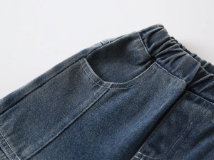 Detail of boys' denim jeans showing the elastic waistband and reinforced stitching