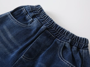 Close-up of boys' denim pants featuring elastic waistband and contrast stitching details