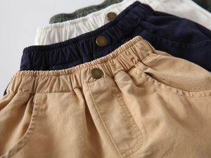 Detail of boys cotton shorts showing elastic waistbands and vintage metal buttons