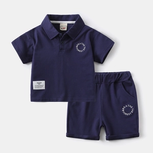 Detail of boys' navy blue cotton polo set with BREATHE THE FOREST printed lettering
