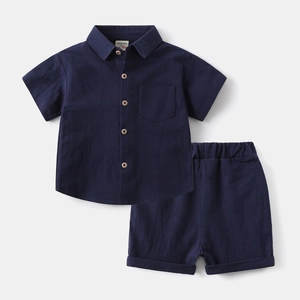 Flat lay of dark blue cotton linen kids set showing shirt pocket and elastic shorts