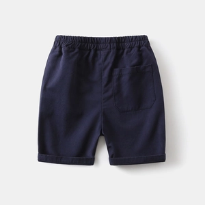 Detail of dark blue boys' cotton shorts showing elastic waistband and back pocket