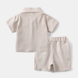 Close-up of minimalist beige cotton polo shirt and shorts set for toddler boys in summer