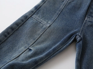 Close-up of boys vintage blue jeans showing durable twill texture and stitching