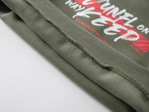 Detailed close-up of ribbed cuffs and high-quality printed typography on green hoodie