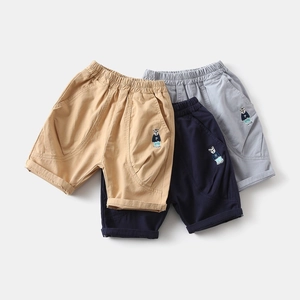 Close-up of three kids cotton shorts with elastic waistbands and bear embroidery detail