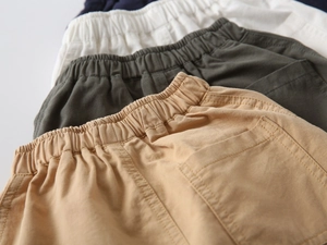 Close-up of cotton boys shorts showing elastic waistbands and rear pockets in multiple colors