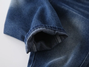Detail of stone-washed blue denim boys pants showing high-quality double-stitched hem