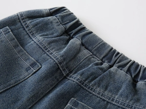 Detail of elastic waistband and stitching on boys' classic dark blue vintage denim jeans