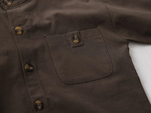 Detail of boys' coffee brown cotton linen shirt showing wood buttons and chest pocket
