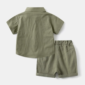 Back view of a green kids' cotton linen short sleeve shirt and shorts set flat lay