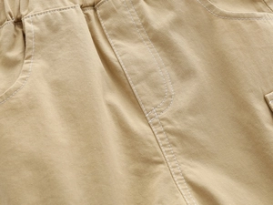 Close-up of elastic waistband and khaki cotton twill fabric on kids casual shorts